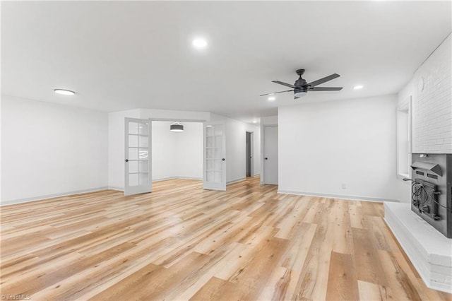 unfurnished living room with ceiling fan, light hardwood / wood-style floors, and french doors