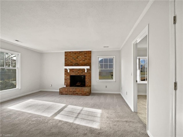 unfurnished living room with ornamental molding, a fireplace, light colored carpet, and a textured ceiling