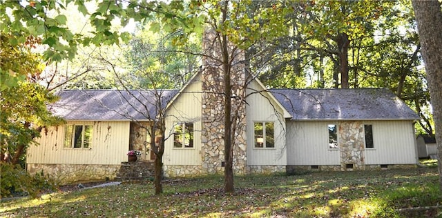 rear view of property featuring a lawn