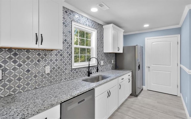 kitchen with sink, ornamental molding, stainless steel appliances, light stone countertops, and light hardwood / wood-style floors