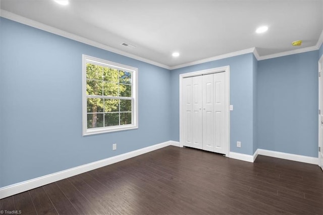 unfurnished bedroom with a closet, ornamental molding, and dark hardwood / wood-style flooring