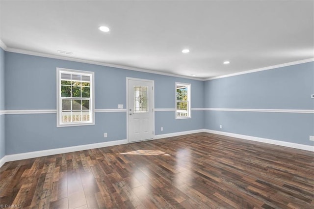 empty room with dark wood-type flooring, crown molding, and a wealth of natural light