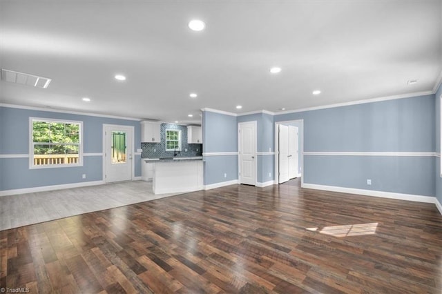 unfurnished living room featuring crown molding and dark hardwood / wood-style flooring