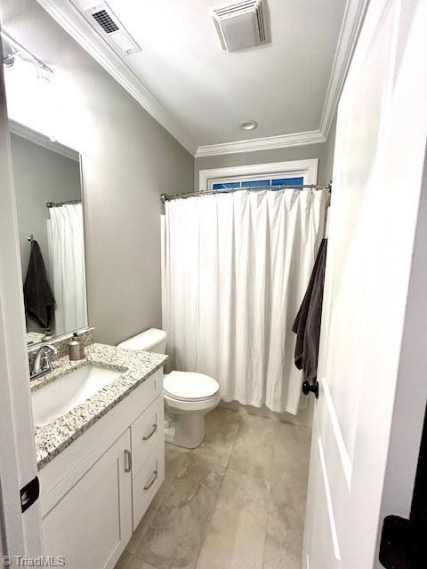 bathroom with toilet, vanity, and ornamental molding