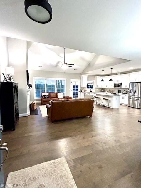 living room with lofted ceiling, ceiling fan, and dark hardwood / wood-style flooring