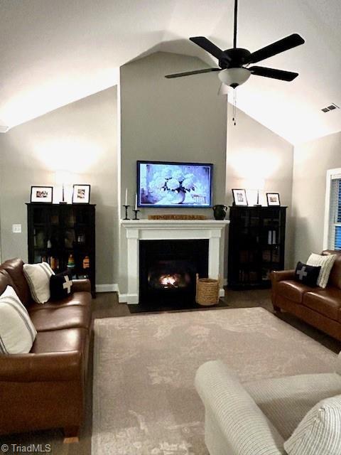 living room featuring ceiling fan and lofted ceiling