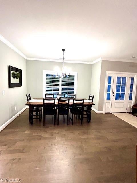 dining area with an inviting chandelier, ornamental molding, and dark hardwood / wood-style floors