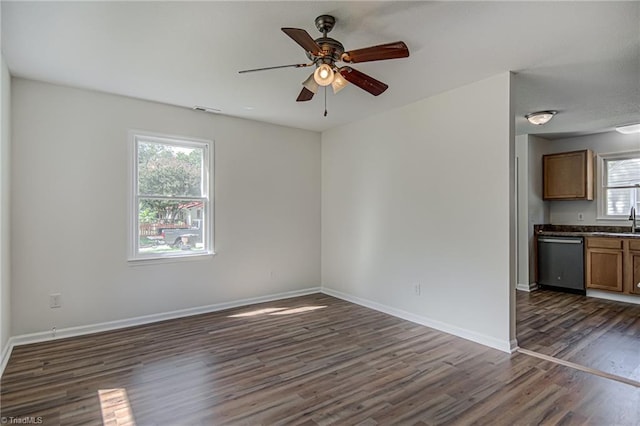 unfurnished living room with sink, ceiling fan, and dark hardwood / wood-style flooring