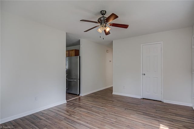 empty room with ceiling fan and light hardwood / wood-style flooring