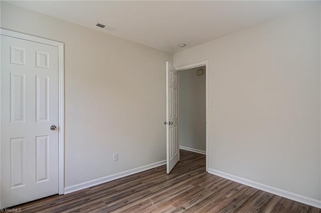 unfurnished bedroom with dark hardwood / wood-style flooring