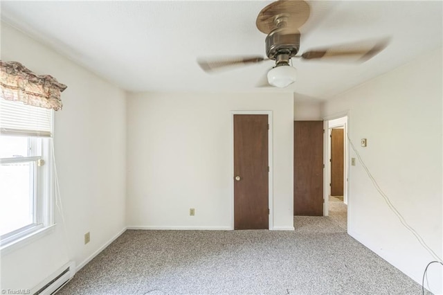 carpeted empty room with ceiling fan and baseboard heating