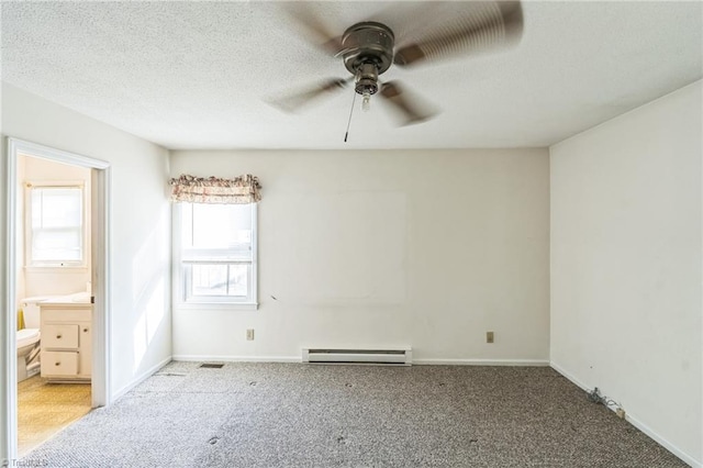 unfurnished bedroom featuring a baseboard heating unit, ensuite bath, light colored carpet, and ceiling fan