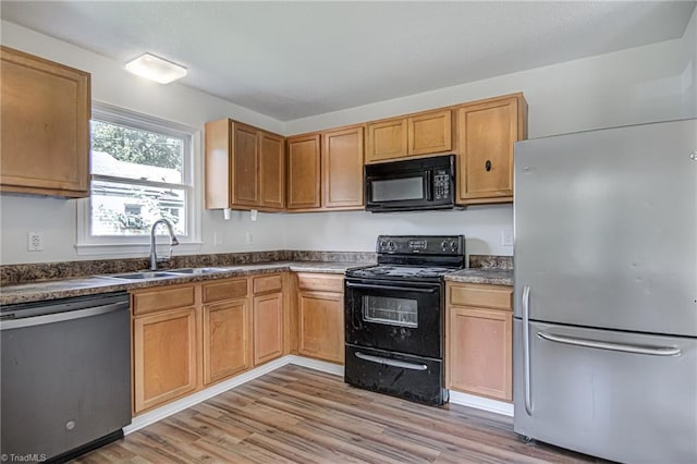 kitchen featuring light hardwood / wood-style flooring, black appliances, and sink