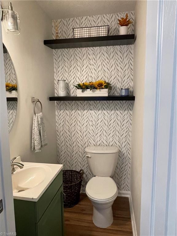 bathroom featuring vanity, toilet, hardwood / wood-style flooring, and a textured ceiling