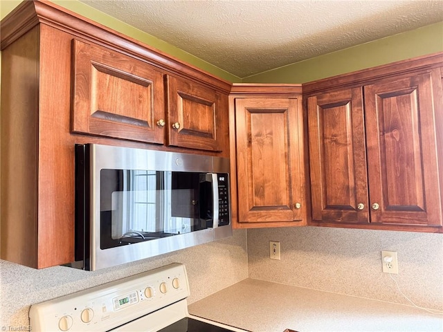 kitchen with white electric range and a textured ceiling