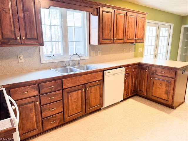 kitchen with french doors, dishwasher, sink, and kitchen peninsula