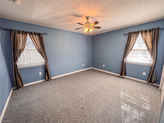 carpeted empty room featuring ceiling fan and a textured ceiling