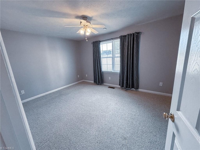 unfurnished room featuring ceiling fan, carpet floors, and a textured ceiling