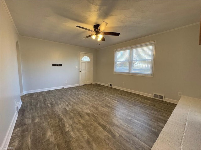 interior space with ceiling fan, dark wood-type flooring, and ornamental molding