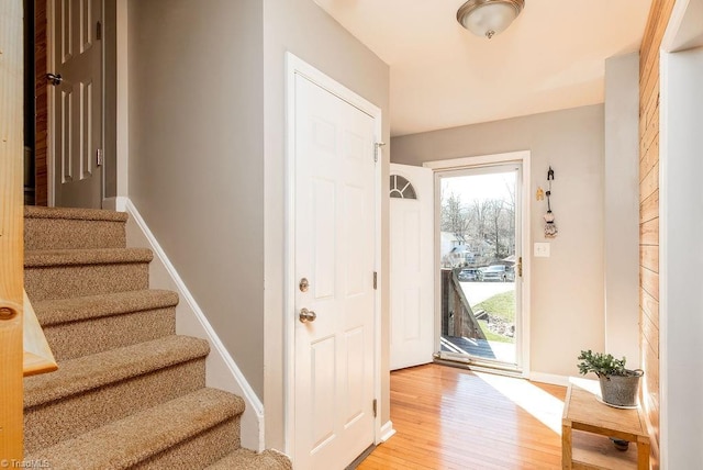 entryway featuring stairway, light wood-style flooring, and baseboards