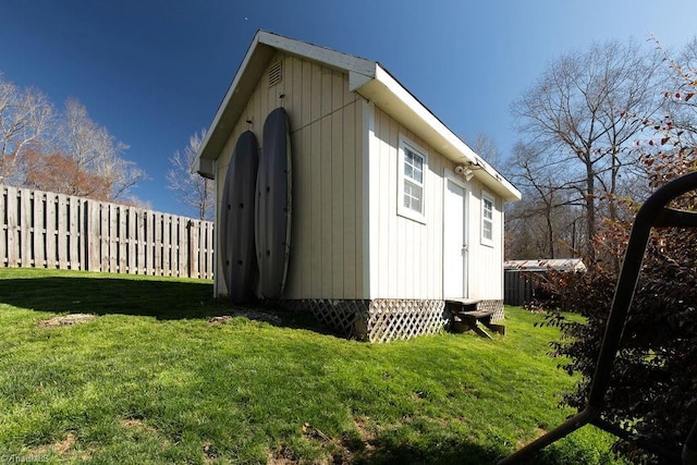 view of side of property featuring a lawn, a shed, an outdoor structure, and fence