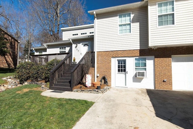 view of front of property featuring a garage, a front yard, brick siding, and driveway