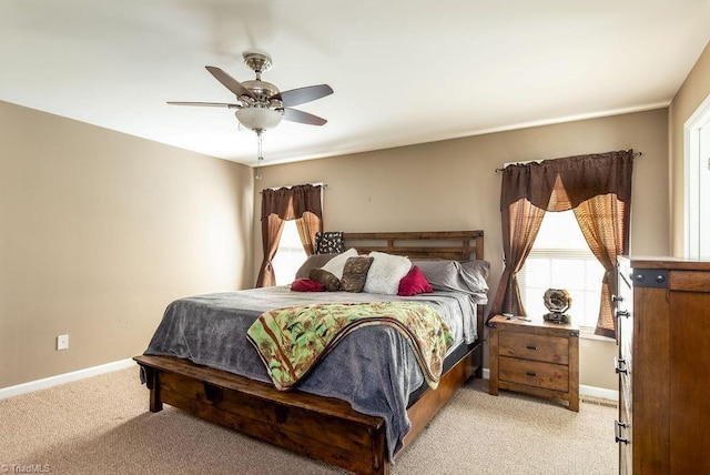 bedroom featuring light carpet, ceiling fan, and baseboards