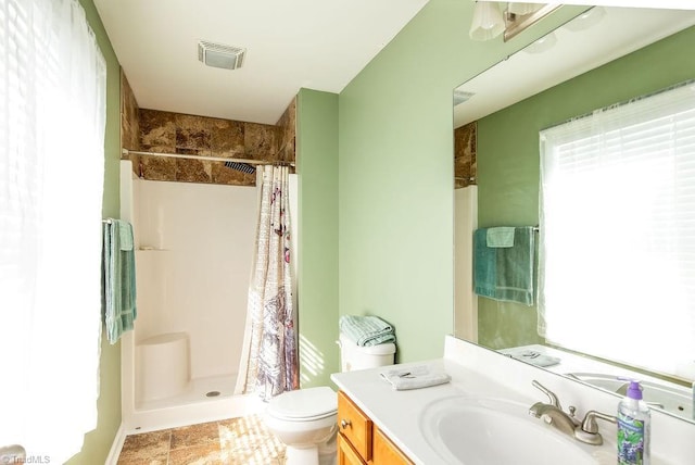 bathroom with toilet, curtained shower, visible vents, and vanity