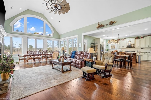 living room with ceiling fan, dark hardwood / wood-style floors, and high vaulted ceiling