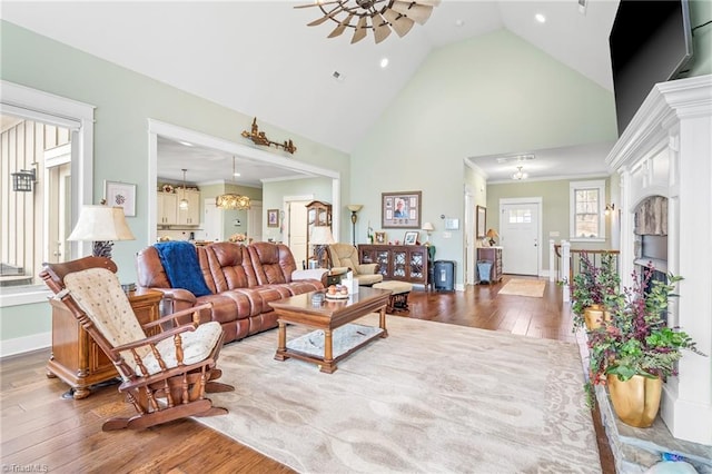 living room featuring hardwood / wood-style floors, crown molding, high vaulted ceiling, and ceiling fan