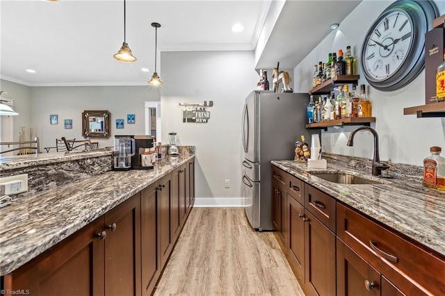 kitchen with sink, crown molding, light hardwood / wood-style flooring, stainless steel refrigerator, and light stone countertops