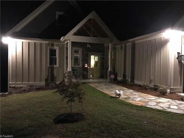 back house at twilight with a lawn