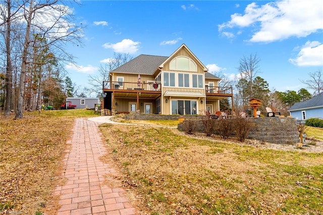 back of house featuring a wooden deck and a lawn