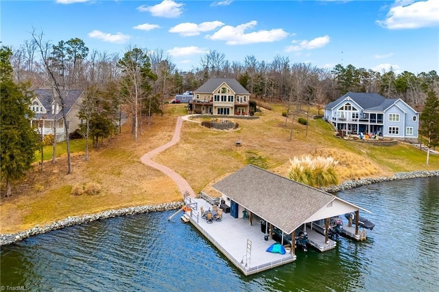 view of dock with a lawn and a water view