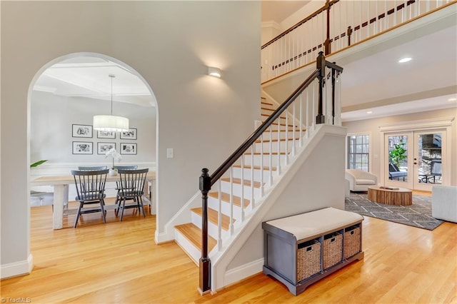 stairway featuring french doors, hardwood / wood-style flooring, and crown molding