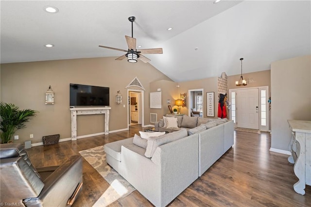 living room featuring vaulted ceiling, ceiling fan with notable chandelier, and dark hardwood / wood-style flooring