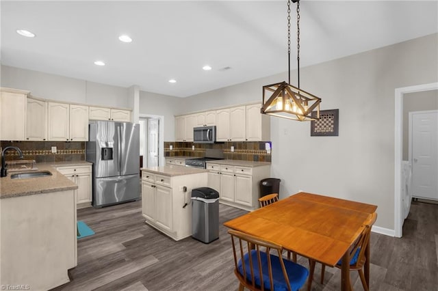 kitchen featuring dark wood-style floors, backsplash, appliances with stainless steel finishes, and a sink