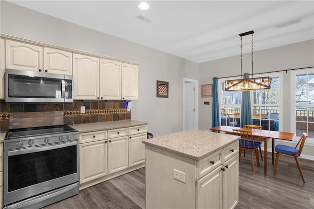 kitchen with dark wood finished floors, tasteful backsplash, visible vents, and appliances with stainless steel finishes