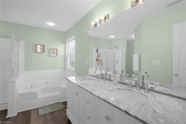 full bathroom with a sink, visible vents, a garden tub, and double vanity