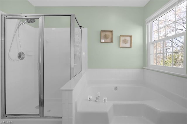 bathroom featuring a garden tub and a shower stall