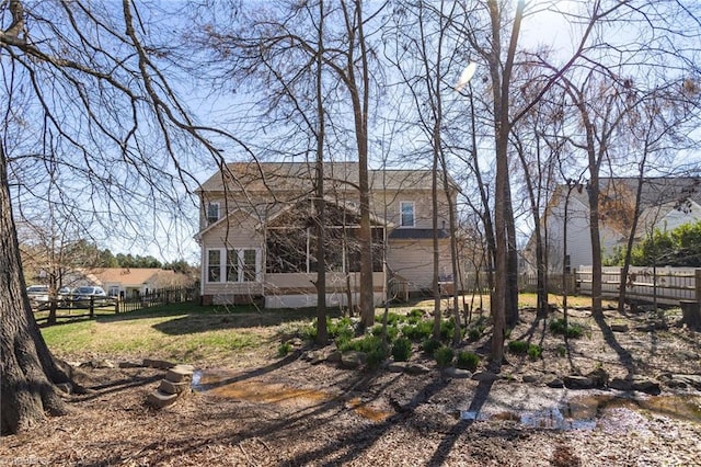 back of house with a fenced backyard and a sunroom
