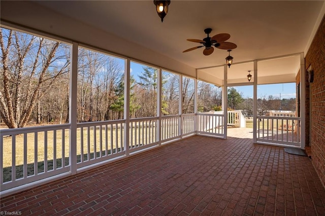 unfurnished sunroom featuring ceiling fan