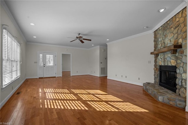 unfurnished living room featuring a fireplace, ornamental molding, ceiling fan, and light wood-type flooring