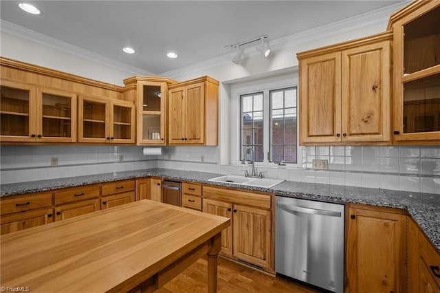 kitchen featuring sink, crown molding, stainless steel dishwasher, dark stone counters, and backsplash