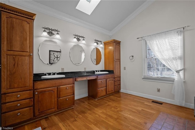 bathroom featuring crown molding, vanity, and hardwood / wood-style flooring