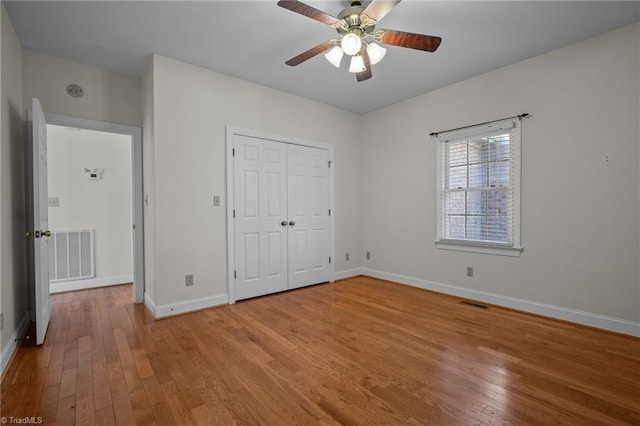 unfurnished bedroom with light hardwood / wood-style floors, a closet, and ceiling fan