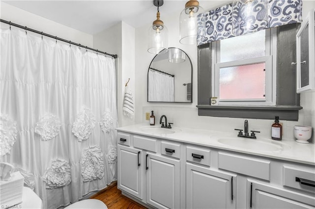 2065 Craig St, Winston-Salem, NC 27103 - full bathroom featuring double vanity, backsplash, a shower with curtain, and wood finished floors
