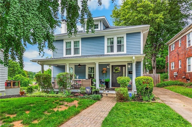 2065 Craig St, Winston-Salem, NC 27103 - american foursquare style home featuring a porch, a front yard, and a chimney