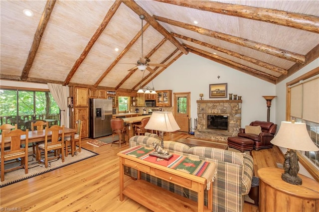 living room with beamed ceiling, a wealth of natural light, and light hardwood / wood-style flooring