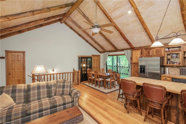 living room featuring light hardwood / wood-style floors, ceiling fan, beam ceiling, and high vaulted ceiling